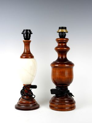 une paire de lampes en bois et en marbre posées sur des socles, sur fond blanc