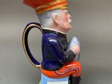 a figurine of a man sitting on a stool holding a cell phone