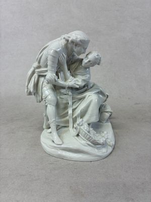 une statue représentant un homme tenant un enfant sur ses genoux
