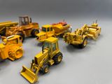 beaucoup de petits engins de chantier en jouets posés sur la table