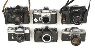 several cameras are lined up in a row on a white surface