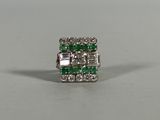 a close up of a green and white diamond ring
