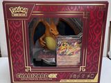 La boîte est ouverte pour montrer la figurine du Pokémon Charizard.