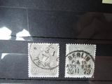 Deux timbres représentant une horloge sont exposés dans une vitrine
