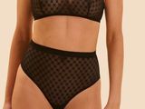 the woman is wearing a black bra top and black panties