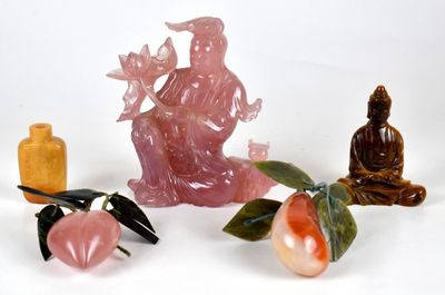 trois figurines assises côte à côte sur une surface blanche