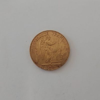 gros plan d'une pièce d'or sur une surface blanche