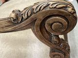 a close up of a wooden chair with a carved seat