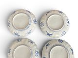 four blue and white plates with designs on them on a white surface