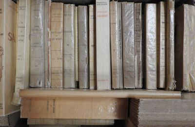 de nombreux livres empilés sur une étagère dans une pièce