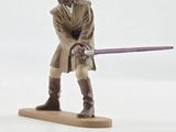 figurine of a man with a sword on a white surface