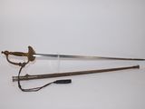 une vieille épée avec un manche en bois sur une surface blanche