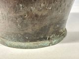 a close up of a metal bowl on a white surface