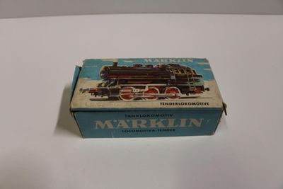 une vieille boîte avec un train dessiné dessus, posée sur une table
