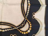 an image of a black and white scarf with gold beads on it