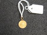 une petite pièce d'or à laquelle est attachée une étiquette