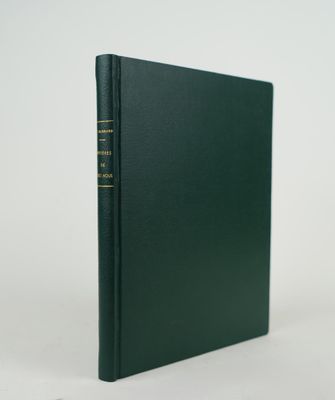 un livre vert orné de lettres dorées, posé sur une surface blanche