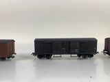 three toy train cars sitting side by side on a white surface
