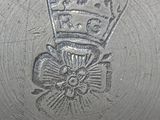 a silver vase with a crown on the top of it