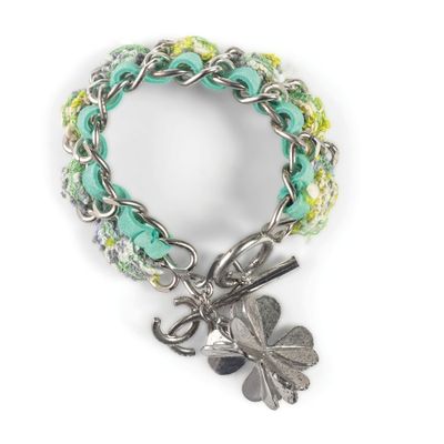 un gros plan sur un bracelet orné d'un pendentif en forme de trèfle