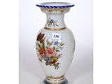 a white vase with a floral design on it
