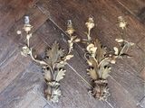 two gold colored sconces on a wooden floor