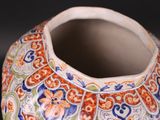 a close up of a colorful vase on a black surface
