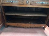 a wooden cabinet that has a shelf on top of it