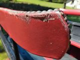 a close up of a red bench in a park