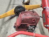 a small engine sitting on the ground next to a yellow and red fire hydrant