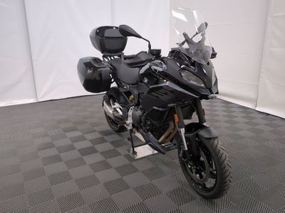 une photo d'une moto noire garée sur un sol à damier