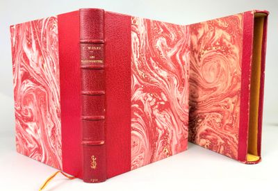 un livre rouge ouvert posé sur une table près d'un mur blanc