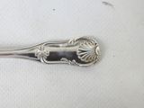 a silver spoon that is sitting on a white surface