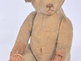 un ours en peluche marron assis par terre