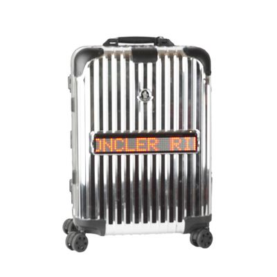 silver and black luggage with orange lettering on wheels on a white background