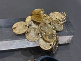 a bunch of gold coins sitting on top of a crystal block