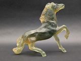 statue of a horse on its hind legs on a gray surface