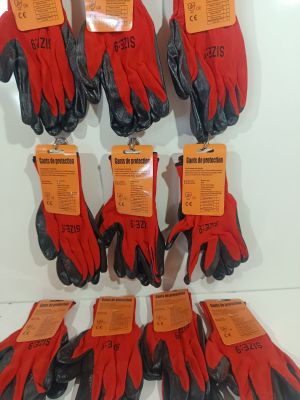 six pairs of red and black gardening gloves hanging on a wall