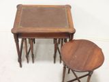 three wooden tables with leather tops sit on a white floor