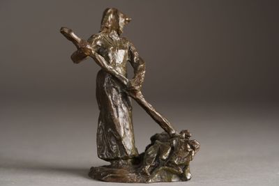 a bronze statue of a man with a cross and a dog