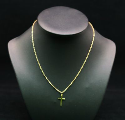 un collier en or orné d'une croix, posé sur le cou d'un mannequin