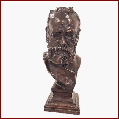 statue représentant le buste d'un homme barbu, posée sur un socle en bois