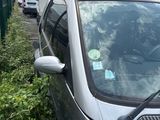 a small silver car parked next to a truck