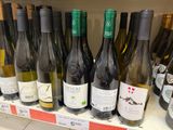 many bottles of wine sitting on a shelf in a store