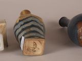 two vases and a small vase are sitting on a table