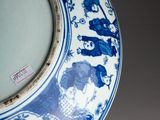 a blue and white plate with a picture of people on it