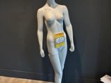 un mannequin dans une pièce, avec un mur noir en arrière-plan