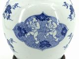 a blue and white vase with a lid on a wooden stand
