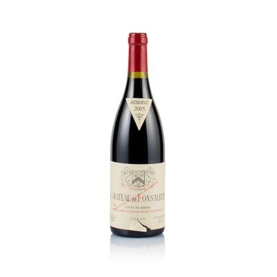 a bottle of red wine sitting on top of a white table