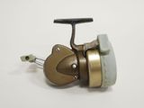 a small fishing reel with a handle on a white surface